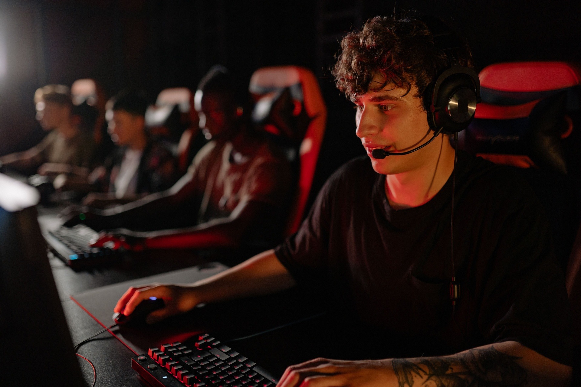 Echipă esports într-o cameră de strategie, cu hărți și overlay-uri pe un ecran mare